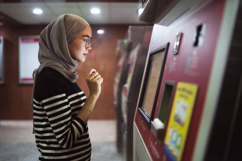 Young woman using ATM to check funds. Getty Images