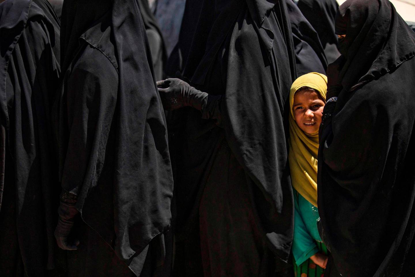 (FILES) In this file photo taken on August 18, 2020 a girl stands in line to receive aid with women at the Kurdish-run al-Hol camp in the al-Hasakeh governorate in northeastern Syria where families of Islamic State (IS) foreign fighters are held. The United States on August 31, 2020 vetoed a UN resolution on the fate of foreign jihadists which failed to include a call for their repatriation, diplomats said.
Drafted by Indonesia -- a non-permanent member of the Security Council -- the text drew support from 14 members, with the United States the only one to vote against.
 / AFP / Delil SOULEIMAN
