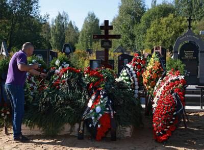 A man places flowers at Chekalov's grave. Reuters