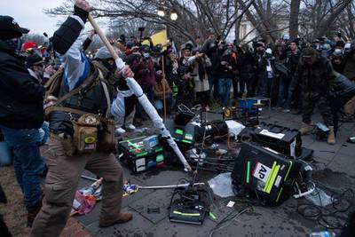 Demonstrators break TV equipment outside the the U.S. Capitol, in Washington. AP Photo