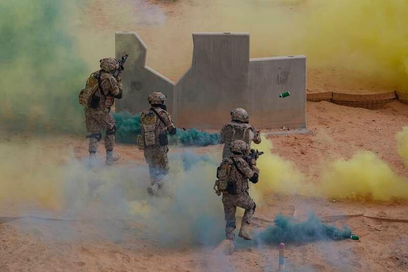 Soldiers run through smoke flares during the military exercise