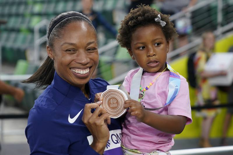 Allyson Felix gives her daughter Camryn her bronze medal after the 4x400m mixed relay final at the World Championships on Friday. AP