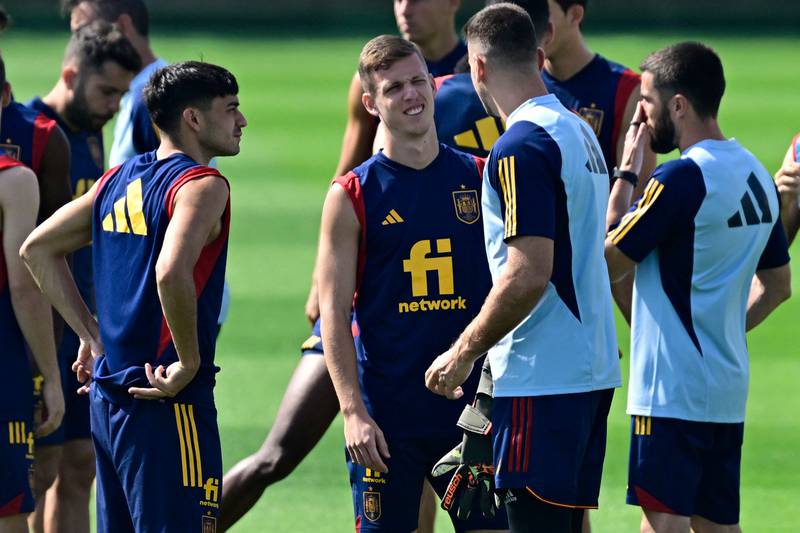 Spain forward Dani Olmo, centre, talks with teammates at a training session. AFP