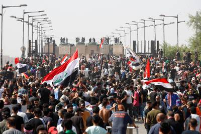 Protesters wave the Iraqi national flag as they attend a protest in Tahrir Square, Baghdad. AFP