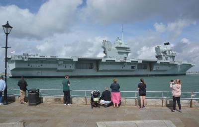 Admirers watch Royal Navy aircraft carrier HMS Prince of Wales sail towards Portsmouth Naval Base. The UK has announced three privately-funded ships to be used for Royal Navy tasks. PA