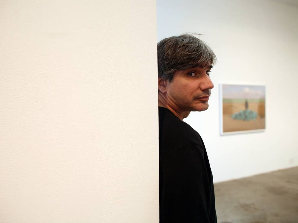 Tarek Al-Ghoussein poses for his portrait amid samples of his work at The Third Line gallery in Dubai on February 12, 2009. Rich-Joseph Facun / The National