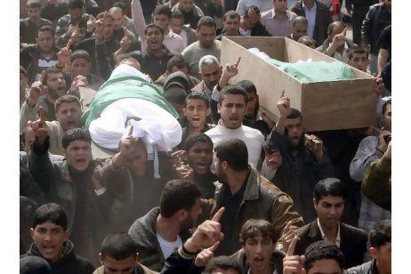 Palestinians carry the bodies of two Hamas militants, the brothers Ismail and Abdullah Lubbad, at their funeral in Gaza yesterday. They were killed along with another man in an Israeli air strike early yesterday. Mohammed Salem / Reuters
