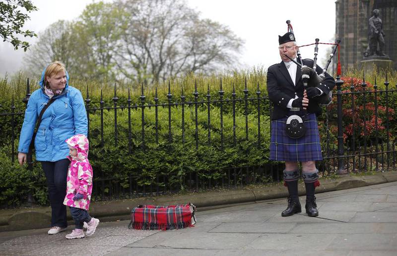 A busker plays the bagpipes on Princes Street, the main shopping street in Edinburgh. Suzanne Plunkett / Reuters