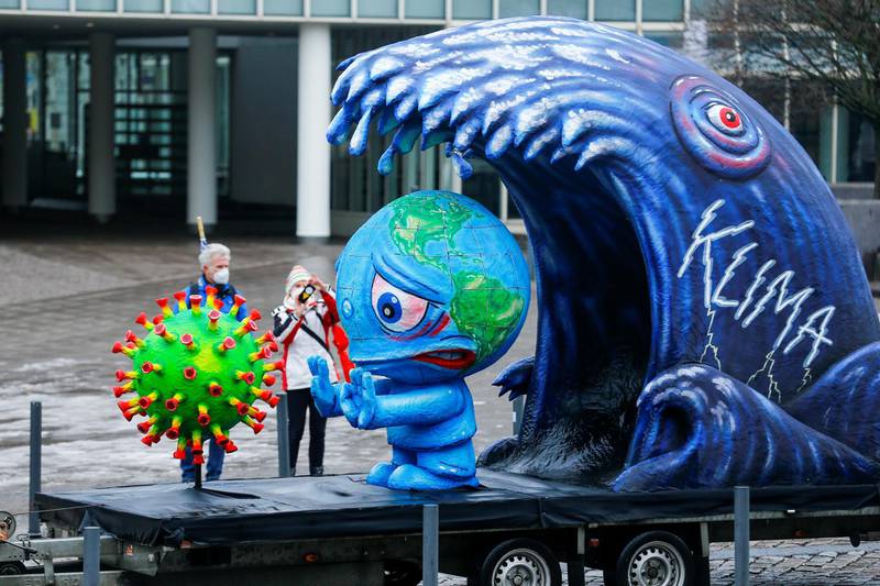 A carnival float displays figures depicting the climate change, personification of the planet Earth and the novel coronavirus, as the traditional "Rosenmontag" (Rose Monday) parade has been cancelled due to the coronavirus (COVID-19) pandemic, in Duesseldorf, Germany February 15, 2021. REUTERS/Thilo Schmuelgen