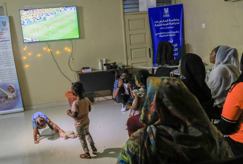 Mothers and children watch Brazil v Switzerland at a club run by a Sudanese women's rights group in Khartoum. Reuters