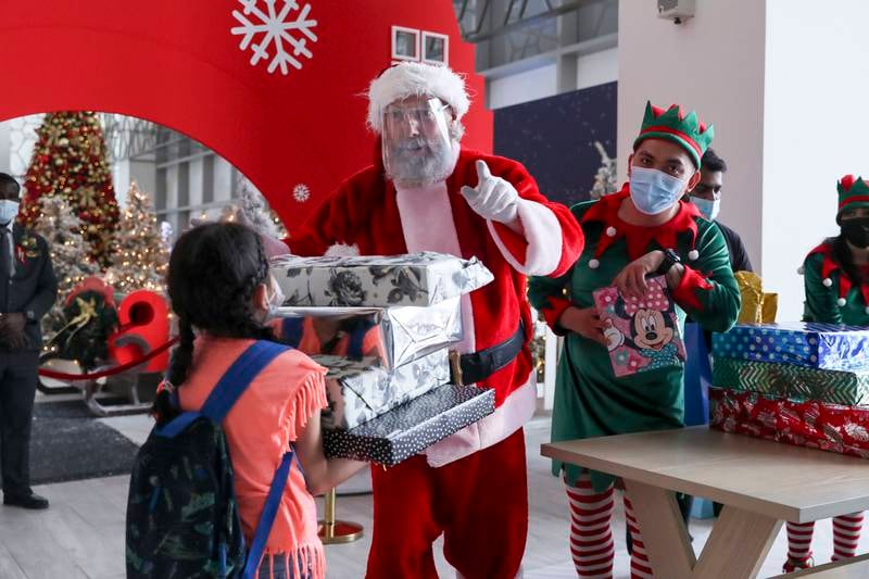 Santa and his elves giving out presents to the children that wrote him letters at Galleria Mall, Abu Dhabi. Khushnum Bhandari / The National