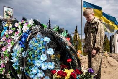 Savelii, 10, mourns at the grave of his father, who died protecting his city as a member of the Territorial Defence, in Irpin, Ukraine. EPA