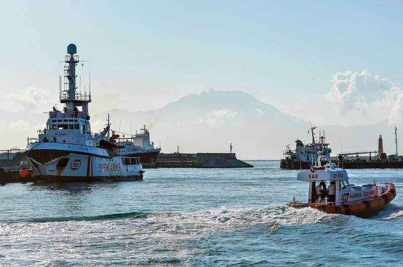 A coast guard vessel navigates past the Ocean Viking docked at left at the Sicilian port of Messina, southern Italy, Tuesday, Sept. 24, 2019. The humanitarian ship has docked in Sicily, Italy, to disembark 182 men, women and children rescued in the Mediterranean Sea after fleeing Libya. (Cesare Abbate/ANSA via AP)