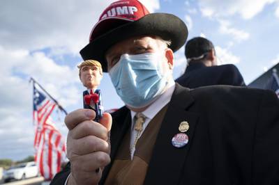 A supporter of US President Donald Trump holds a pen in his likeness outside Walter Reed National Military Medical Centre in Bethesda. Bloomberg