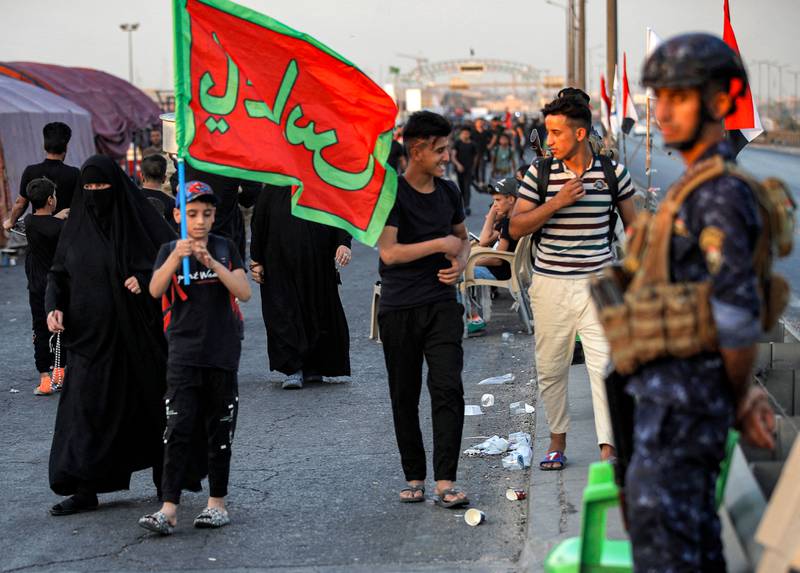 A policeman stands guard as Shiite pilgrims march from Iraq's capital Baghdad on their way to Karbala. AFP