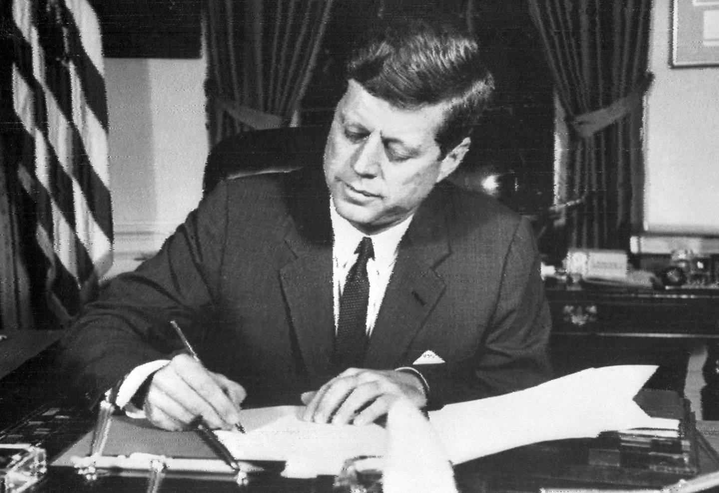 (ARCHIVOS) En esta foto de archivo tomada el 24 de octubre de 1962, el presidente estadounidense John F. Kennedy firma la orden de bloqueo naval a Cuba, en la Casa Blanca, Washington DC, durante la crisis de los misiles cubanos.  (Foto de AFP ARCHIVOS / AFP)