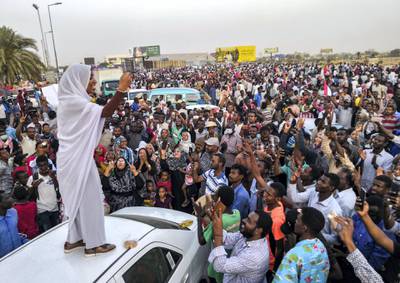 Alaa Salah, a Sudanese woman propelled to internet fame earlier this week after clips went viral of her leading powerful protest chants against President Omar al-Bashir, addresses protesters during a demonstration in front of the military headquarters in the capital Khartoum on April 10, 2019. - In the clips and photos, the elegant Salah stands atop a car wearing a long white headscarf and skirt as she sings and works the crowd, her golden full-moon earings reflecting light from the fading sunset and a sea of camera phones surrounding her. Dubbed online as "Kandaka", or Nubian queen, she has become a symbol of the protests which she says have traditionally had a female backbone in Sudan. (Photo by - / AFP)