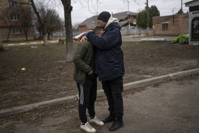 The father and a friend of Anatoliy Kolesnikov, 30, who was killed by Russian soldiers in his car trying to leave Irpin, mourn his death outside the morgue in Bucha. AP