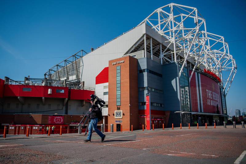 A television cameraman walks past Old Trafford Stadium, the home ground of Manchester United Football Club, in Manchester, U.K., on Monday, April 19, 2021. A group of the world's richest soccer clubs, including Manchester United and Real Madrid, announced plans for a European breakaway league starting in August, a project that could herald the sport's biggest shakeup in decades and make elite teams even wealthier. Photographer: Anthony Devlin/Bloomberg