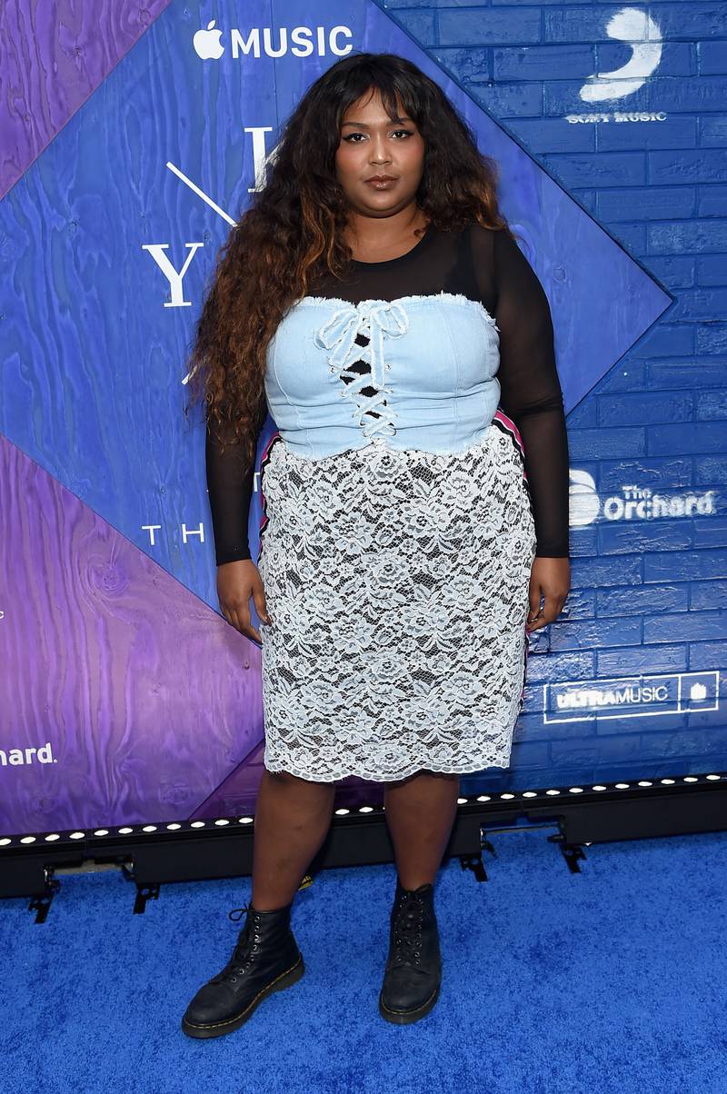 Lizzo wears a black long-sleeved top with denim crop top and lazy skirt with boots in New York City in 2017. Getty Images