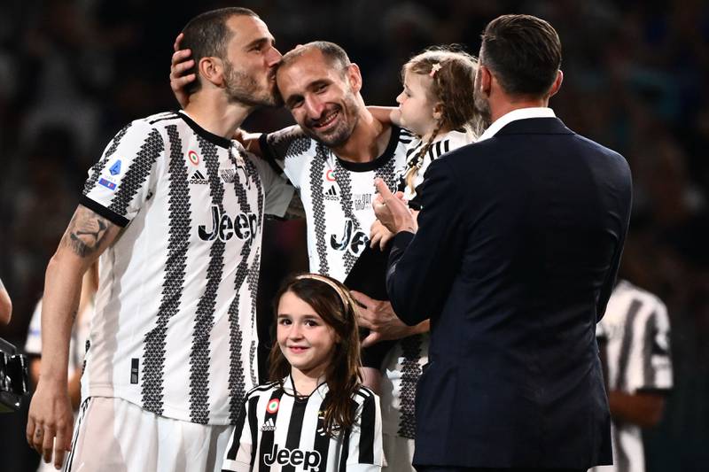 Juventus' Italian defender Giorgio Chiellini poses with his children and longtime defensive partners Leonardo Bonucci, left, and Andrea Barzagli as the stadium pay tribute to him. AFP