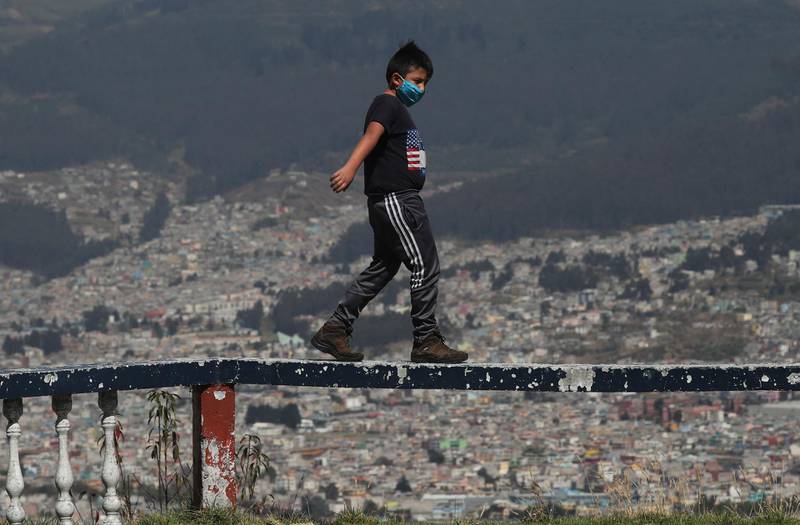 A youth balances on the railing of a popular site overlooking Quito, Ecuador. The country passed 100,000 confirmed cases of Covid-19. AP Photo