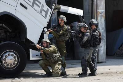 Israeli security troops at the scene of a shooting near Hebron in the occupied West Bank. Reuters