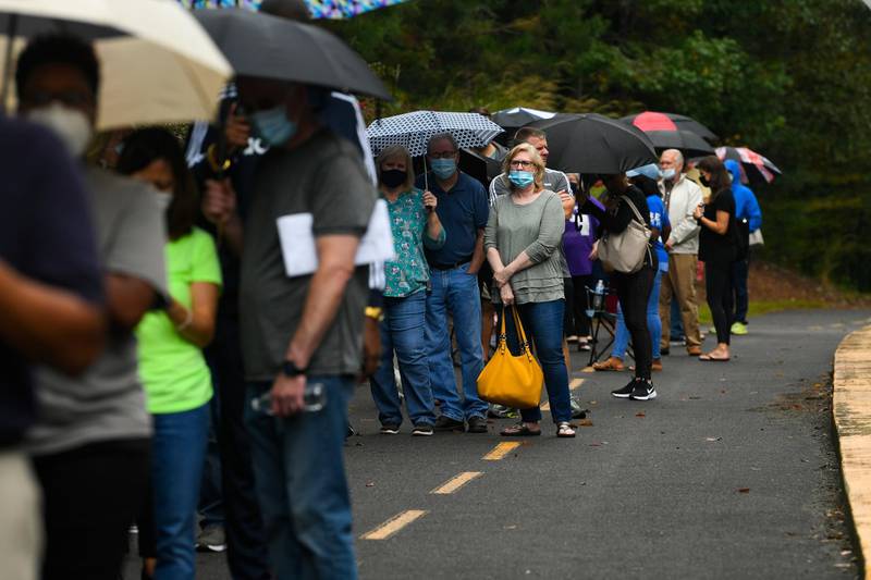 Voters wait in a line to vote that has an estimated 3-hour as the first day of early voting is underway at the George Pierce Park in Suwanee, Georgia, USA.  EPA