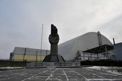 A monument in front of the giant protective dome built over the sarcophagus of the destroyed fourth reactor of Chernobyl nuclear power plant.  AFP