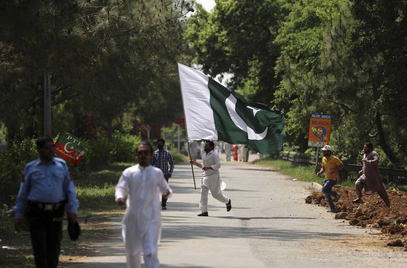 A supporter of ruling party Pakistan Tehreek-E-Insaf holds the national flag during a protest in Islamabad, Pakistan, on April 3. AP