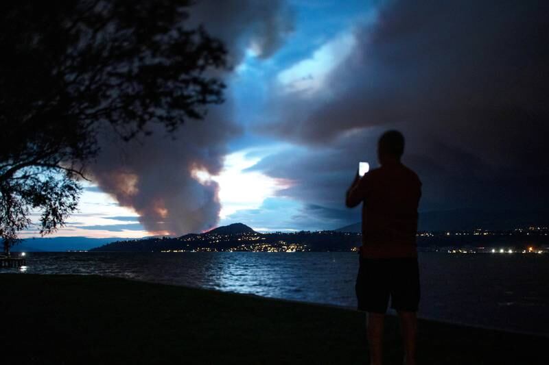 A man takes a photo of the newly ignited Mount Law wildfire in Canada.