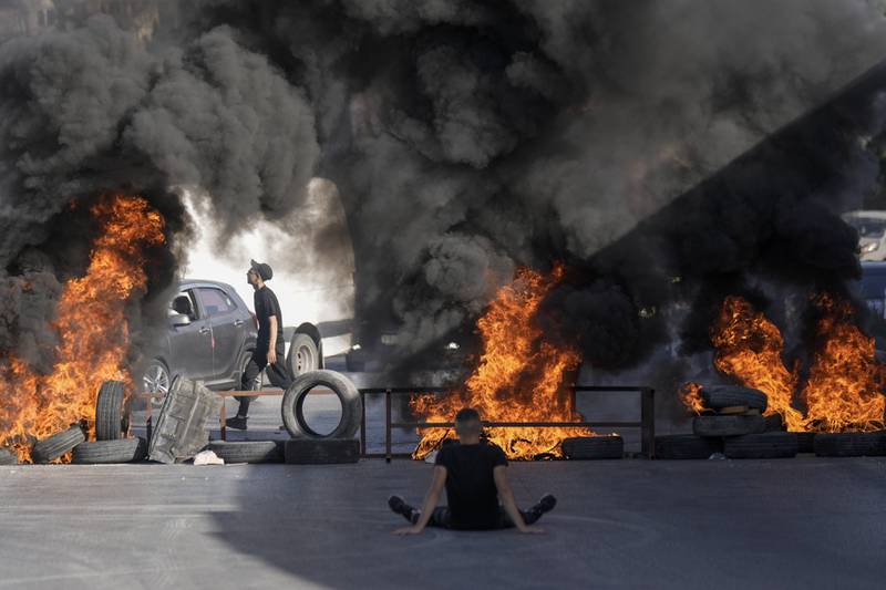 In the West Bank city of Ramallah, tyres burn in the Jalazone refugee camp where two Palestinians were shot dead by Israeli soldiers. The military claims the two tried to ram their car into soldiers during an arrest operation. AP
