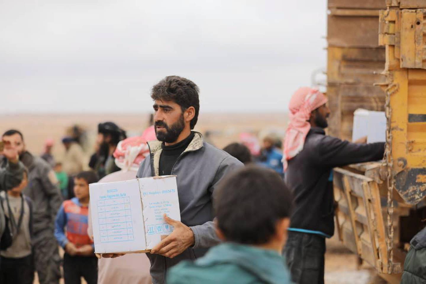 epa07147918 A handout photo made available by Syrian Arabic Red Crescent (SARC) showing a man carrying a box of humanitarian aid distributed by SARC at al-Rukban Camp near the Jordanian border, south-east Syria, 07 November 2018. According to the UN, an operation to deliver humanitarian assistance to 50,000 people in need at Rukban camp in south-east Syria started on 04 November and is expected to take up to four days, the first of kind since the last UN delivery in January 2018, delivered through Jordan.  EPA/SARC HANDOUT  HANDOUT EDITORIAL USE ONLY/NO SALES