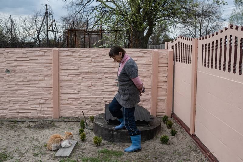 Valentyna, 71, stands by her cat, who was injured in the fighting, in Fenevychi. Getty Images