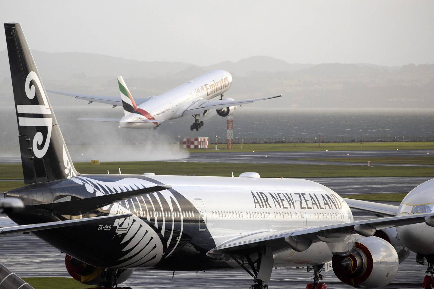 An Emirates Airlines aircraft takes off beyond an Air New Zealand Ltd. aircraft at the International Terminal of Auckland Airport in Auckland, New Zealand, on Tuesday, July 7, 2020. New Zealand’s government will limit the number of citizens flying home with the national airline to reduce pressure on its overflowing quarantine facilities. Photographer: Brendon O'Hagan/Bloomberg