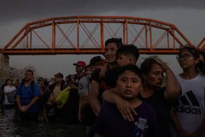 A migrant family from Peru wait to surrender to authorities in Eagle Pass after wading across the Rio Grande river into the United States from Mexico. Reuters