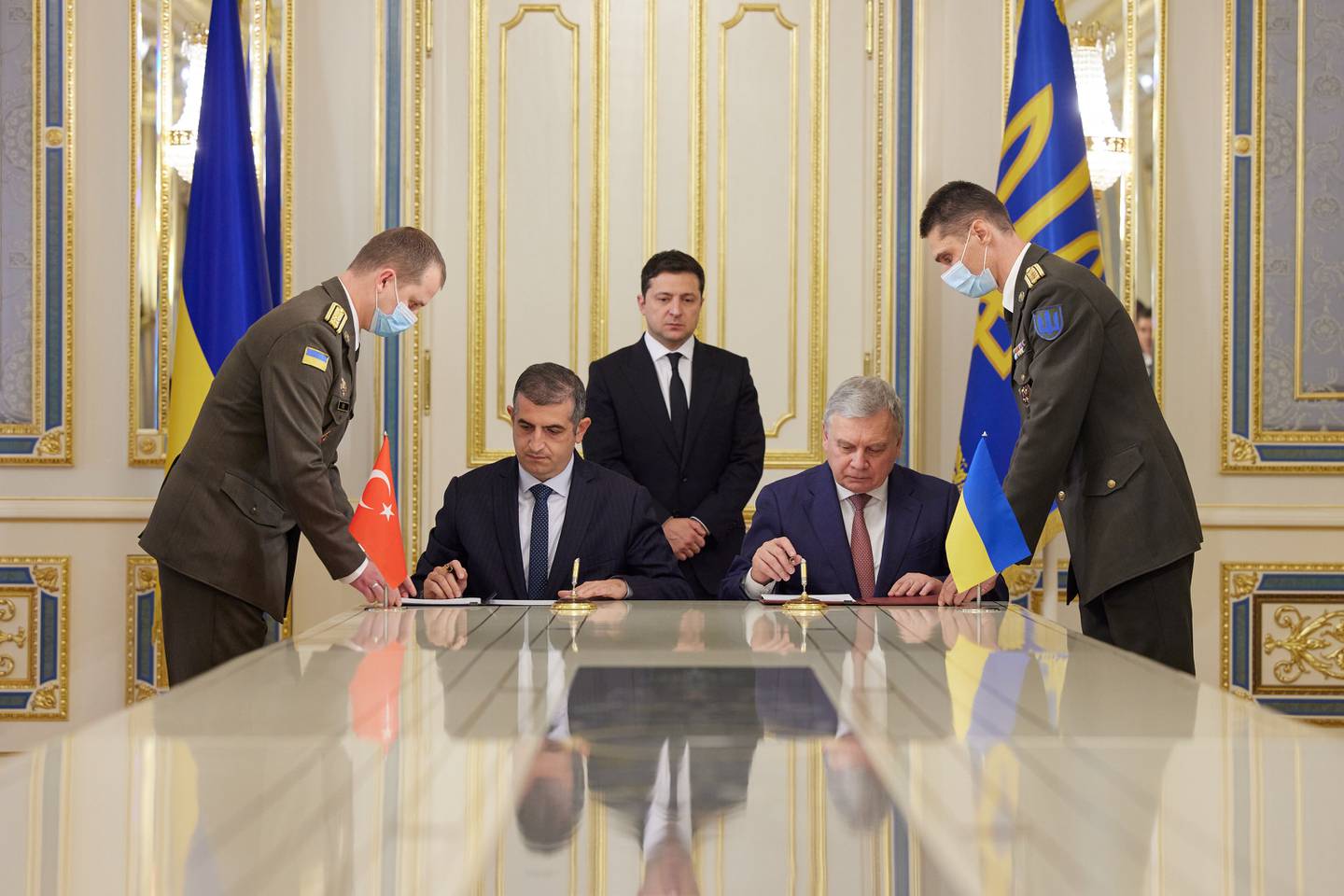 Ukraine's President Volodymyr Zelenskiy looks on while Defence Minister Andriy Taran and CEO of the Turkish defence technology company Baykar Haluk Bayraktar sign a memorandum to establish joint training and maintenance centres for Turkish armed drones in Kiev. Reuters