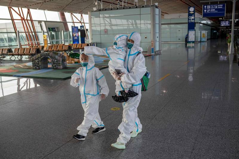 Passengers in full protective suits make their way to their gate at terminal three. AFP