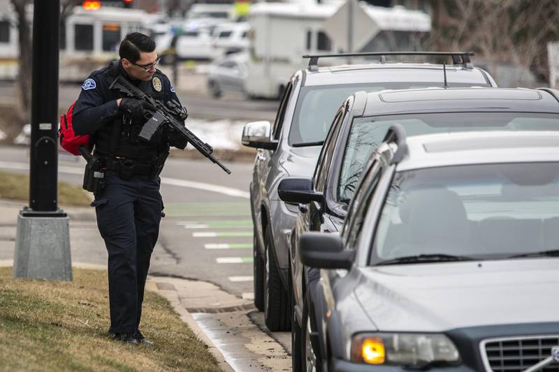 A police officer checks cars in the area after a gunman opened fire at a King Sooper's grocery store. AFP