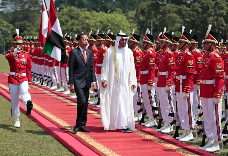 Abu Dhabi's Crown Prince Sheikh Mohammed bin Zayed Al Nahyan, center, inspects honor guards with Indonesian President Joko Widodo during their meeting at the presidential palace in Bogor, Indonesia, Wednesday, July 24, 2019. (AP Photo/Dita Alangkara, Pool)