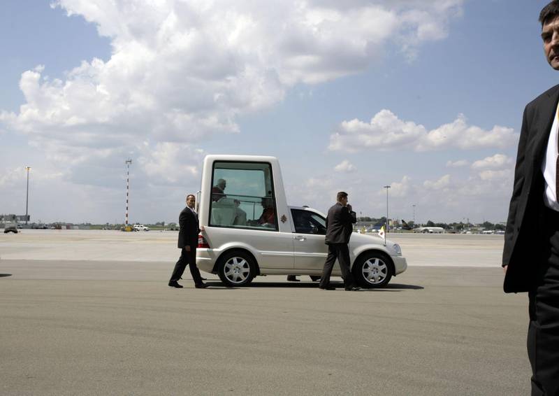 WARSAW, POLAND - MAY 25:  Bodyguards escort the papamobil transporting Pope Benedict XVI after his arrival at Warsaw airport Frederic Chopin May 25, 2006 in Warsaw, Poland. Polish citizens welcomed the German-born Pope at the start of his four-day trip to his predecessor's homeland, which also includes a symbolic visit to the Auschwitz-Birkenau Nazi death camp.  (Photo by Carsten Koall/Getty Images)