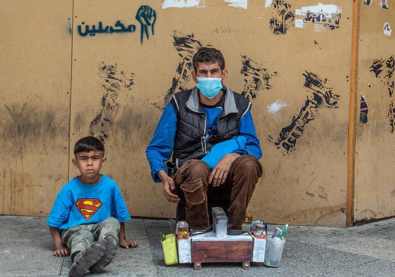 A shoe polisher and his son wait for customers on Hamra Street, Beirut, Lebanon.  EPA