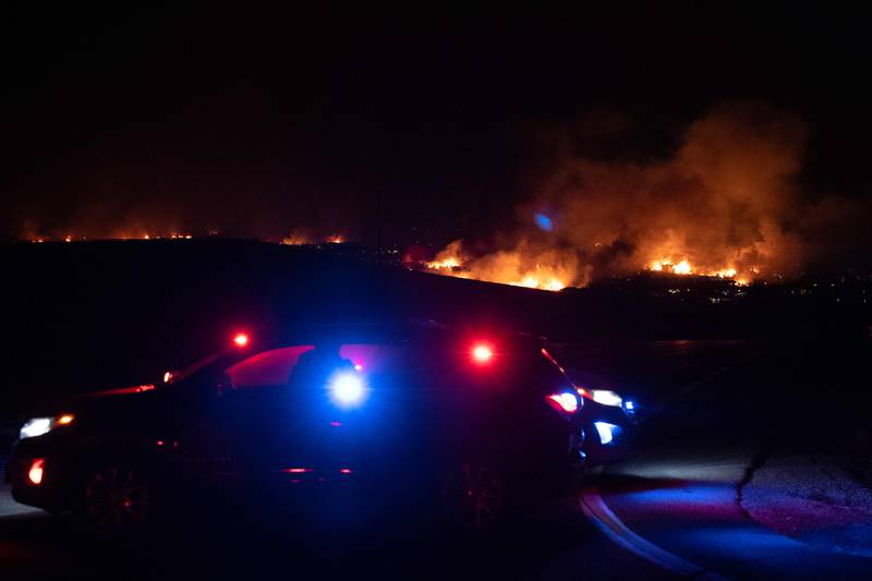 Emergency personnel vehicles are stationed on a closed road leading to a neighbourhood engulfed in flames in the town of Superior in Boulder County, Colorado. AFP