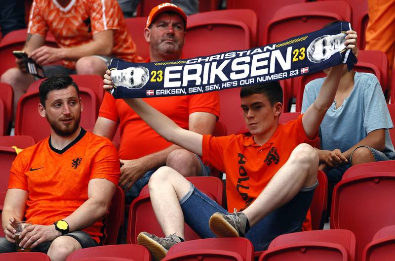 A Dutch fan holds a scarf dedicated to Danish player Christian Eriksen. EPA