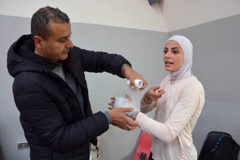 A physical therapist assists Jordanian Juliana Alsadeq, during a Taekwondo training session in Amman, Jordan. All photos: Reuters