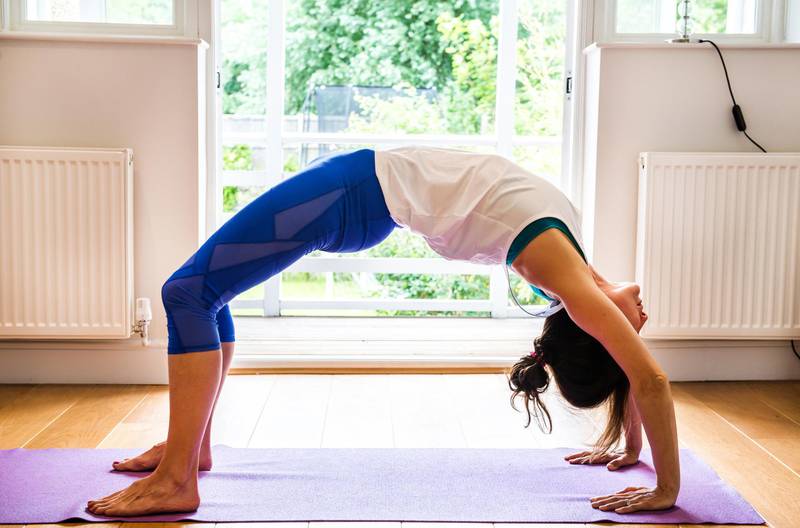 Woman bending over backwards in yoga position.
