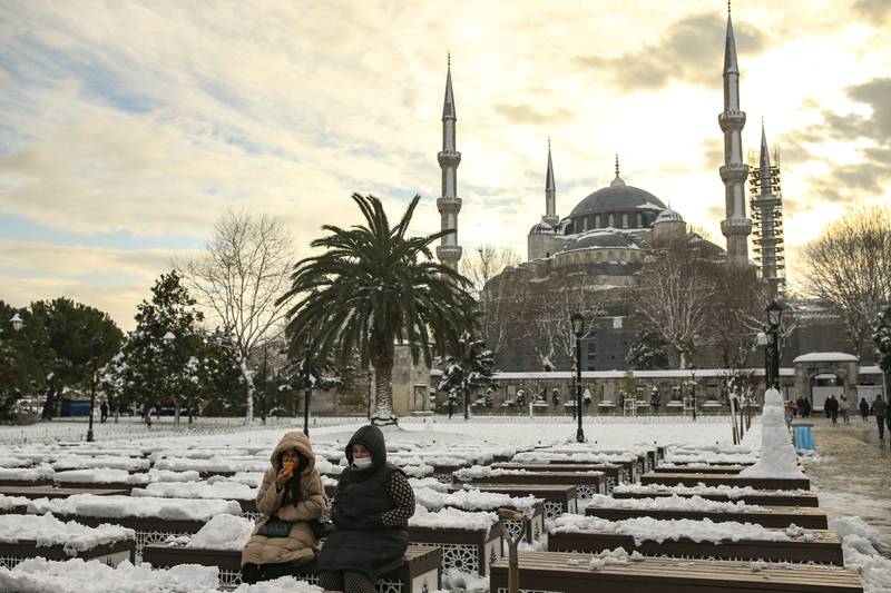 People sit in a snow-covered park with the Blue Mosque in the background in Istanbul after a massive cold front and snowstorms hit much of Turkey and Greece. AP