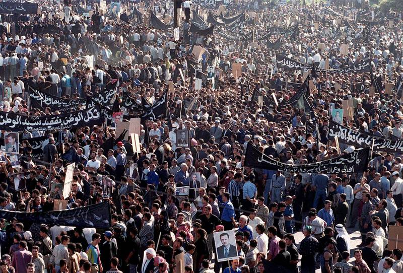 Syrians gather to follow the funeral procession of Syrian President Hafez al-Assad in Damascus 13 June 2000. Assad, who ruled his country for 30 years with an iron fist, died 10 June at the age of 69. (Photo by JOSEPH BARRAK / AFP)