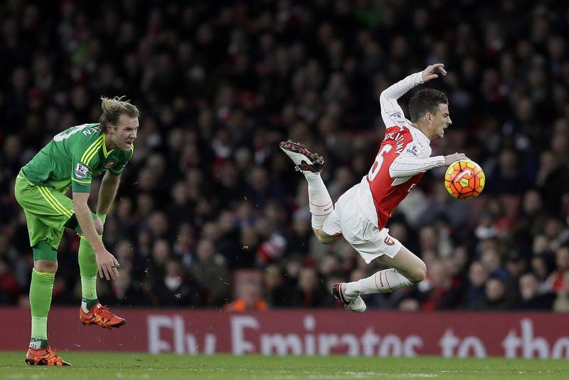 Arsenal’s Laurent Koscielny, right, goes down after a challenge from Sunderland’s Ola Toivonen during the English Premier League soccer match between Arsenal and Sunderland at the Emirates Stadium in London, Saturday Dec. 5, 2015. (AP Photo/Tim Ireland)