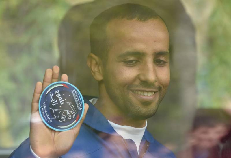 Hazza Al Mansouri holds up the Mohammed bin Rashid Space Centre crest. mission. AFP